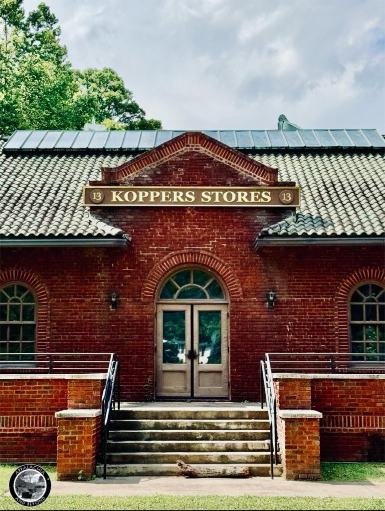 Close view of the central entrance with arched door and pediment sign reading “Koppers Stores” on the Houston Coal Company Store in Kimball, West Virginia.