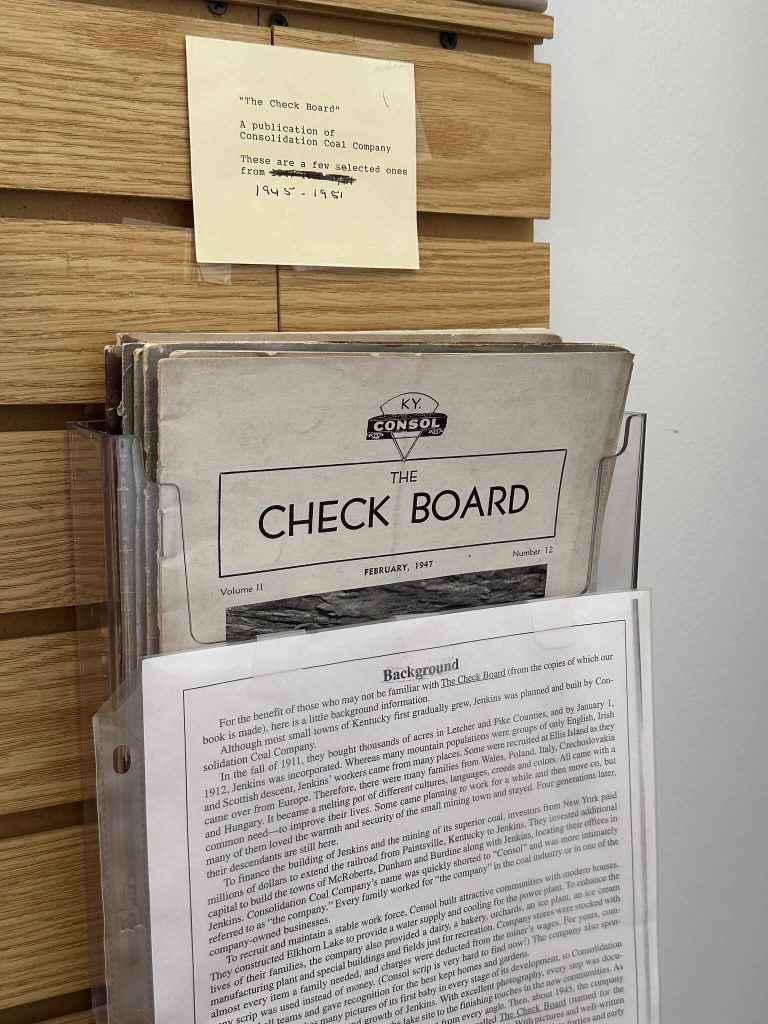 Display rack holding vintage “The Check Board” magazines, with a note reading “A publication of Consolidation Coal Company… 1945–1951.”