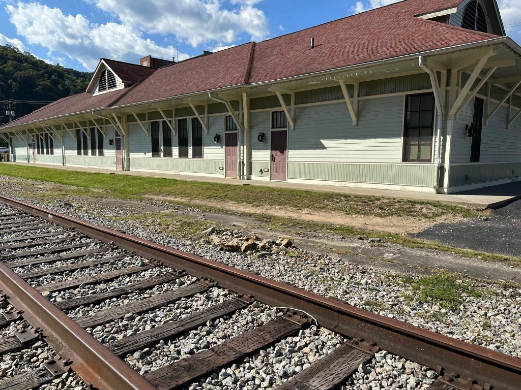 Depot-style Harlan County Extension Depot on River Street in downtown Harlan, Kentucky, viewed beside the railroad tracks.