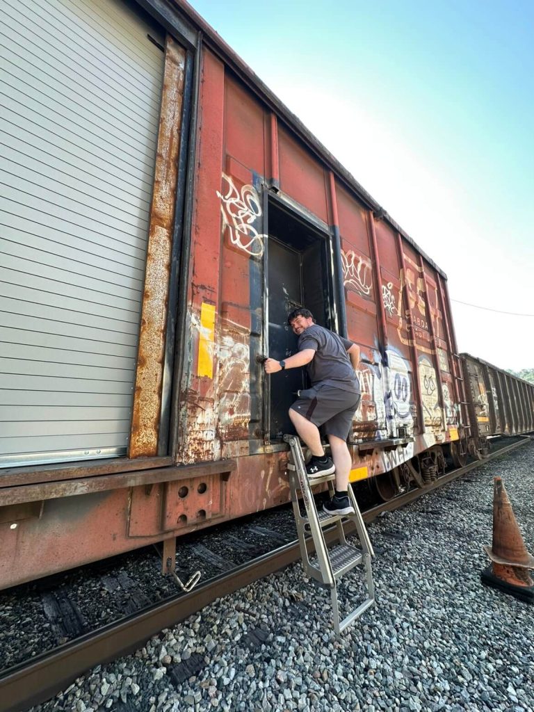 Picture of Alex Hall climbing into a train.